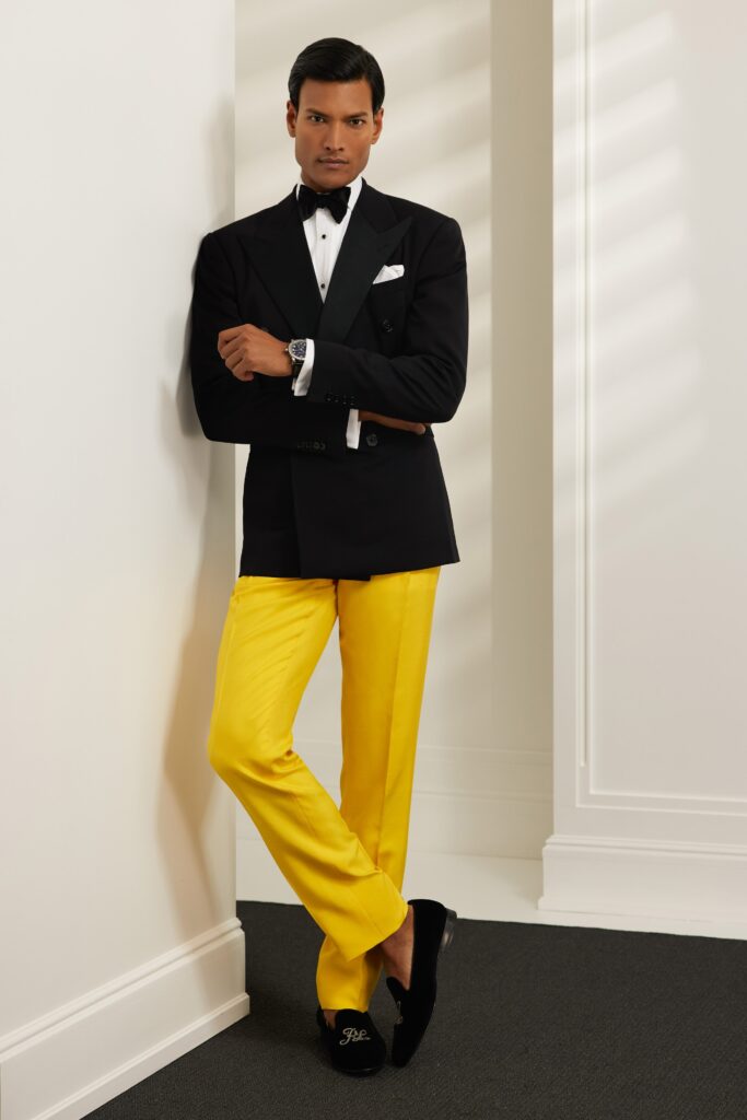 A tailored black blazer with long sleeves paired with straight-leg yellow pants.