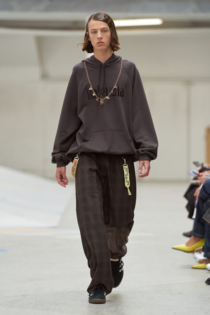 An oversized black hoodie paired with patterned pants for a casual streetwear look.