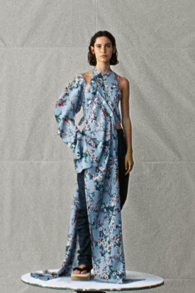 A relaxed blue floral dress with an asymmetric design paired with pants.