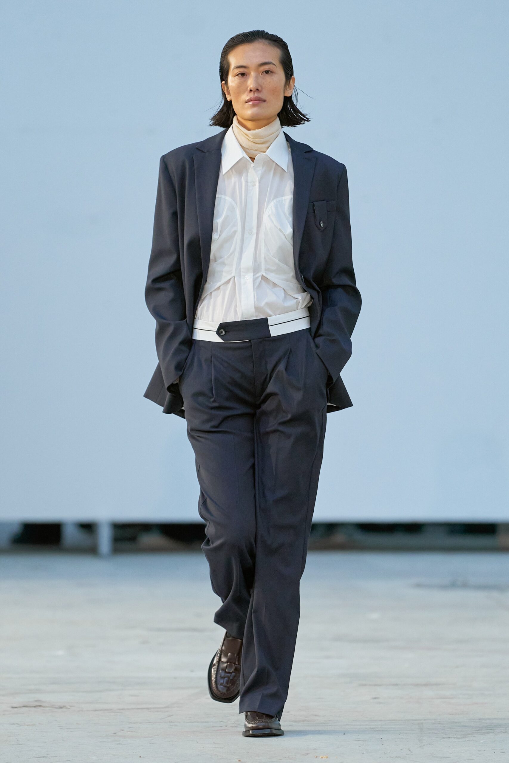 A tailored navy suit featuring a collared long-sleeve shirt and buttoned details.