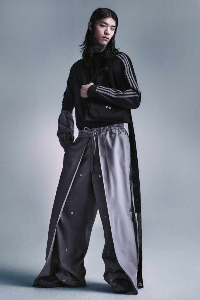 A relaxed black and gray outfit featuring a hooded top and asymmetric zippered pants.
