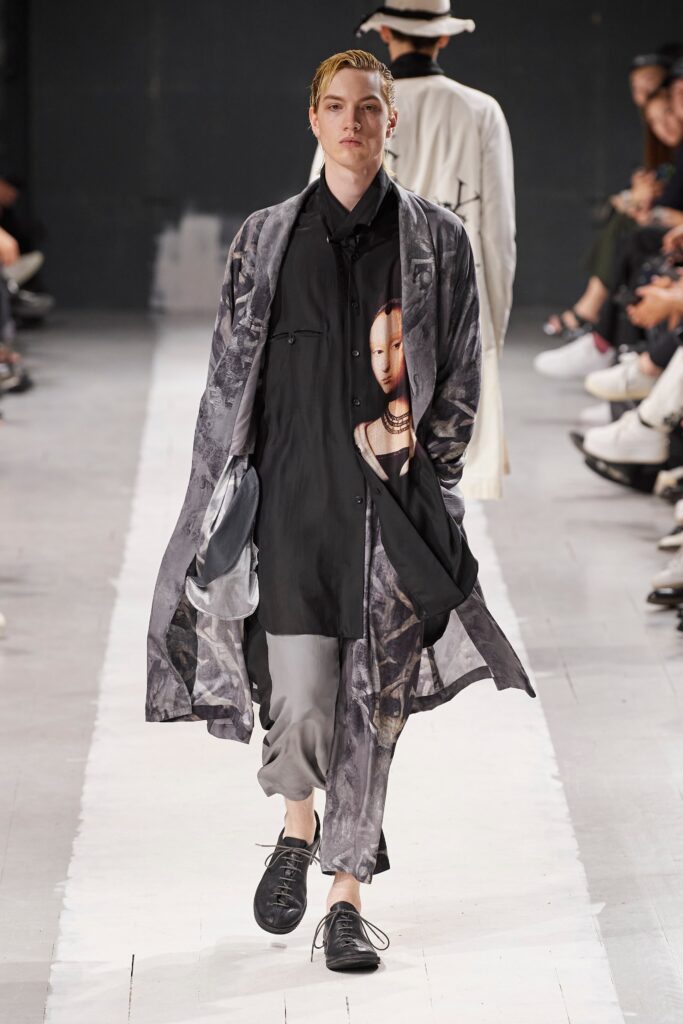 A relaxed black and gray layered coat over a collared shirt with printed details.