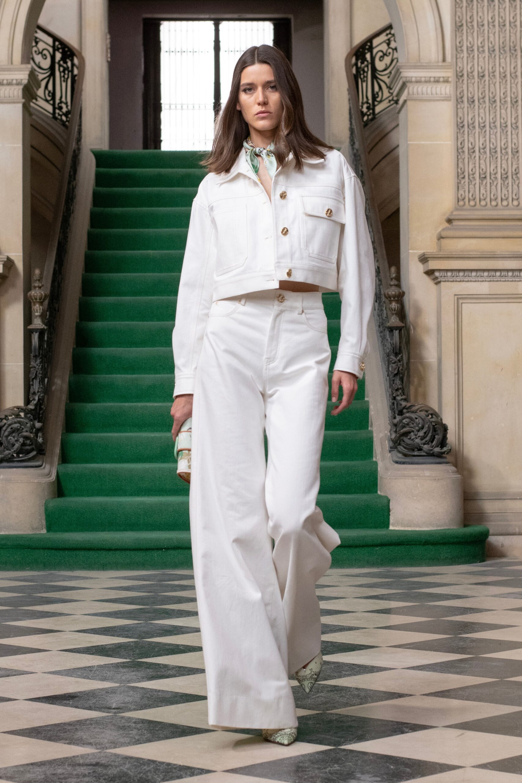 A relaxed white jacket with long sleeves and collared design paired with wide-leg pants.