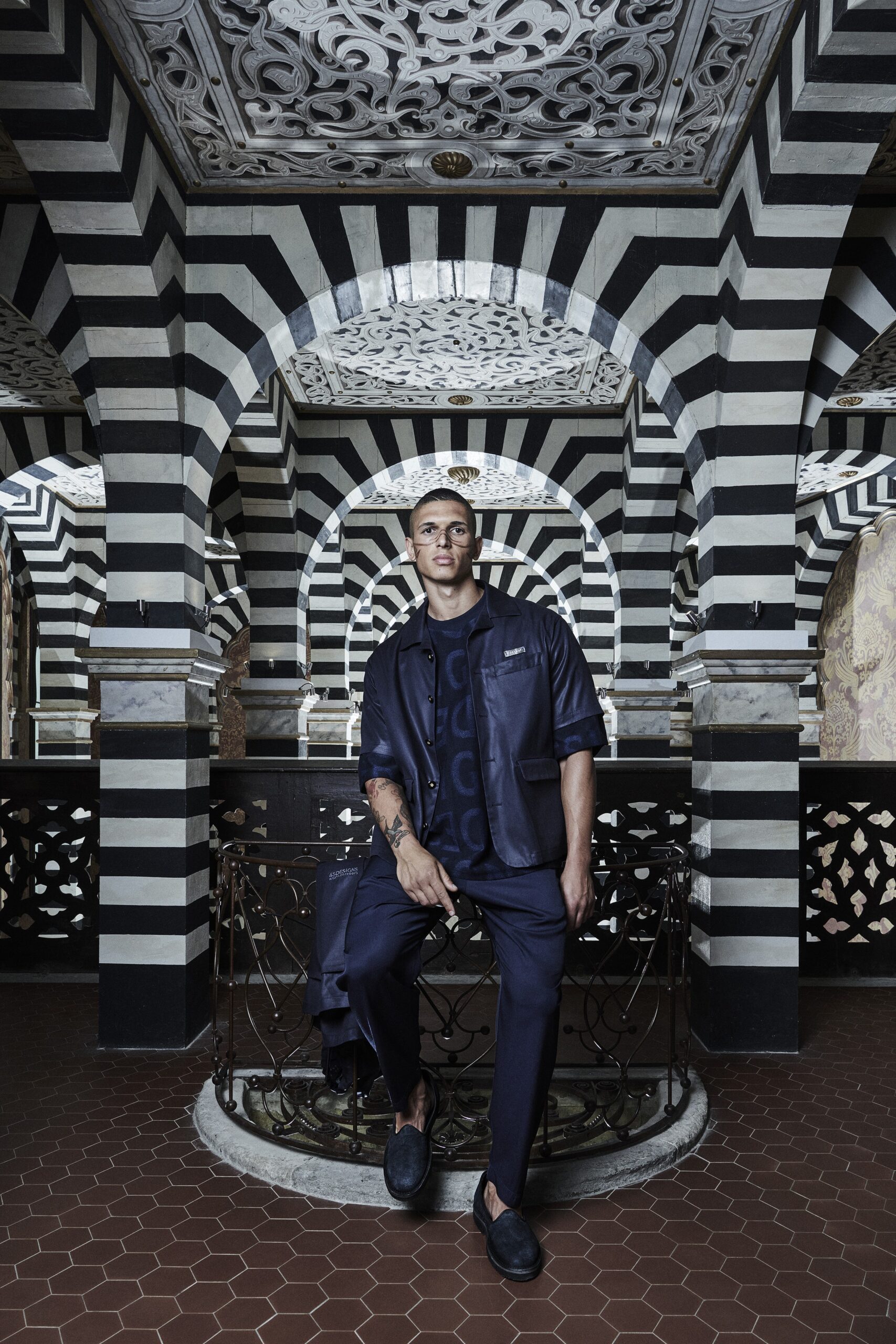 A relaxed navy cotton jacket with long sleeves and collared design paired with straight-leg pants.