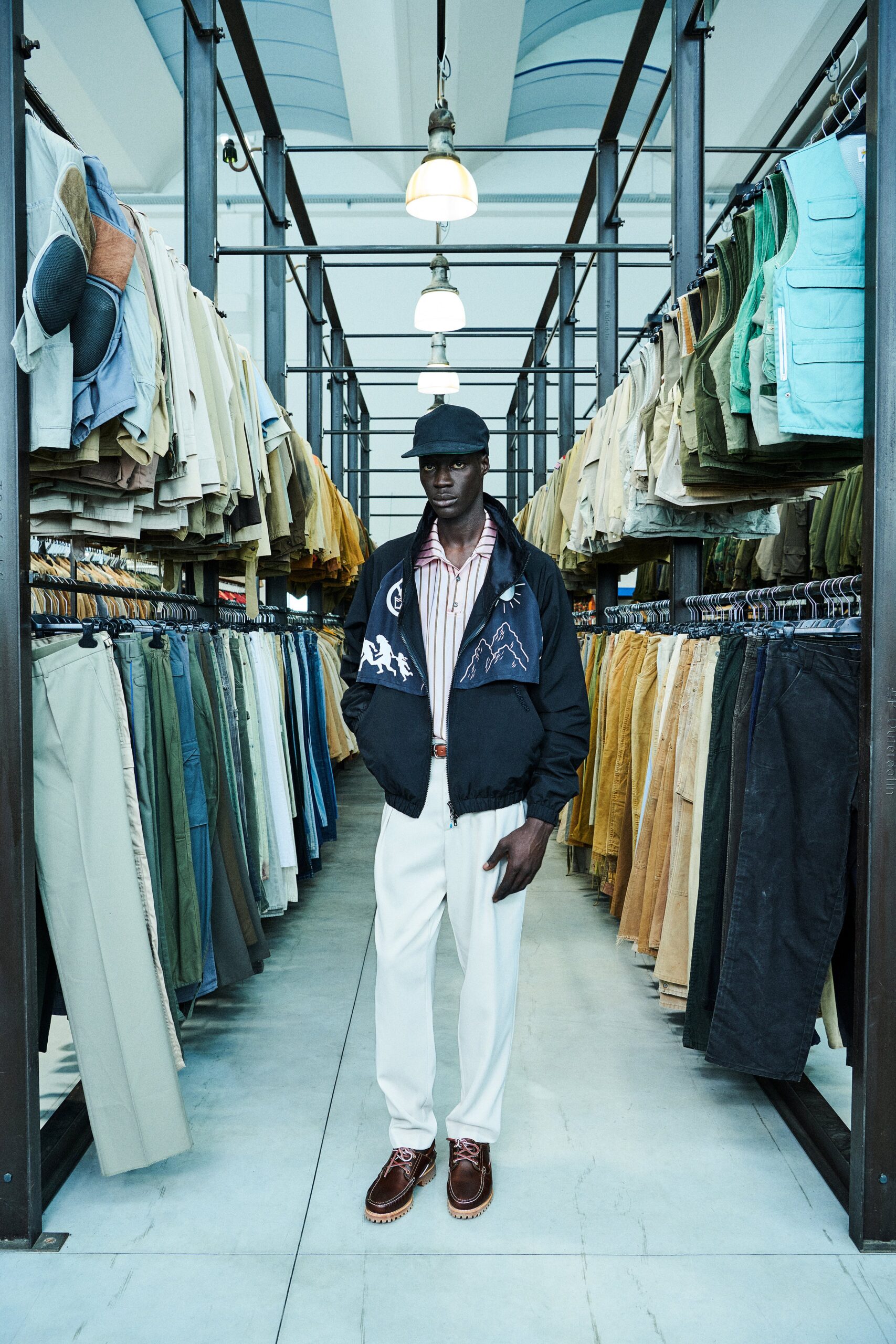 A relaxed black jacket paired with white striped shirt and relaxed white pants.