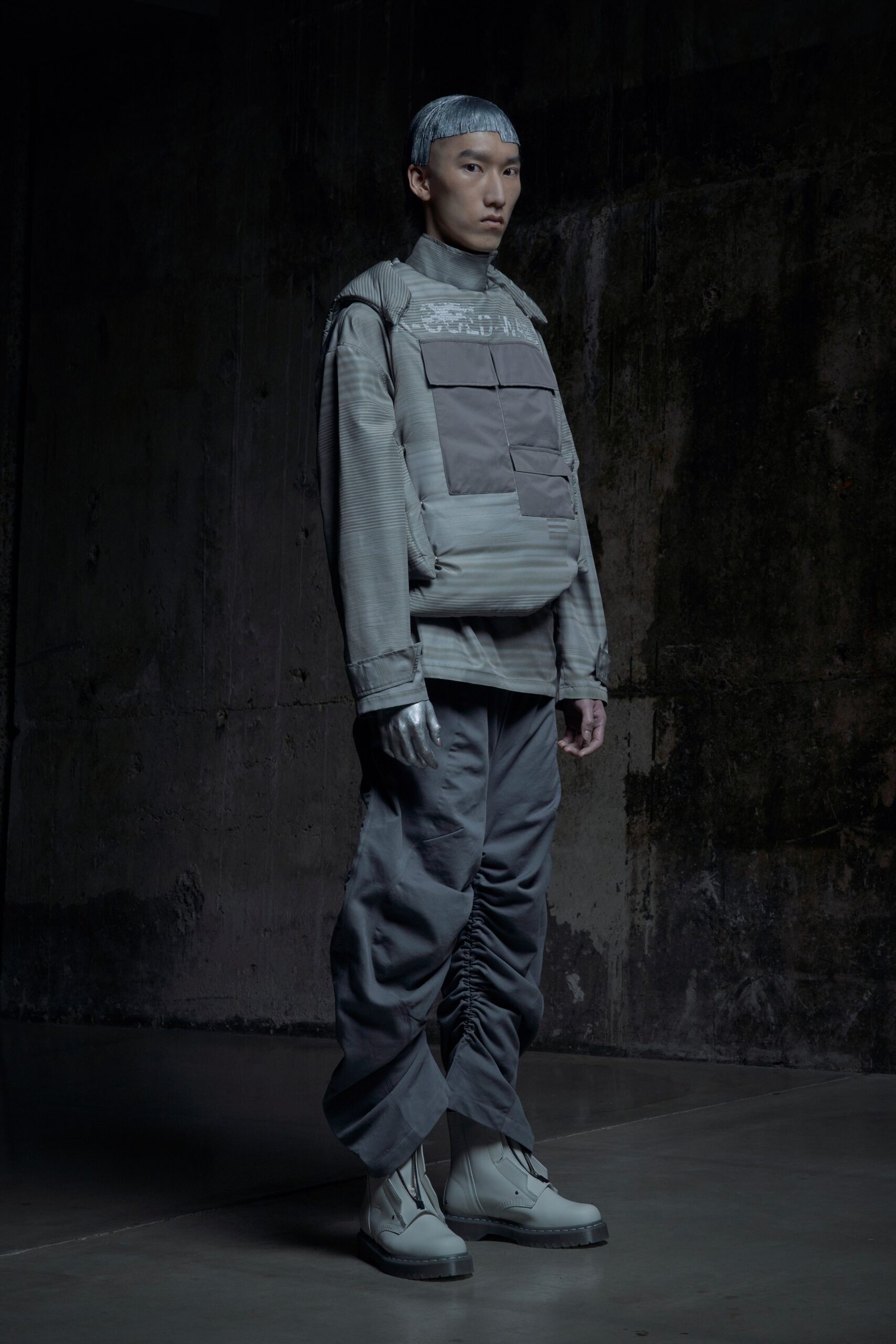 A relaxed gray jacket with long sleeves paired with matching pants featuring zippered details.