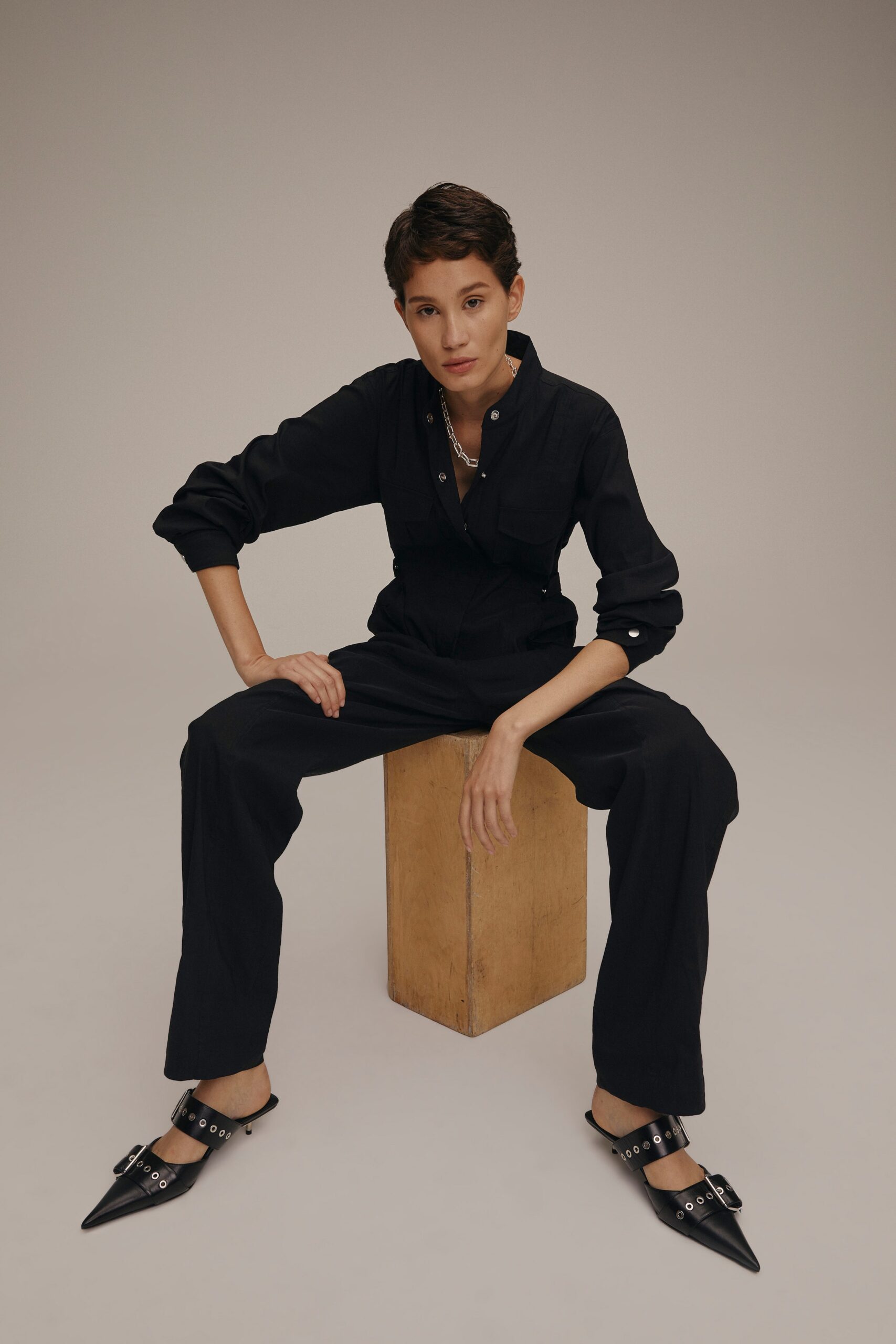 black fitted jumpsuit with pointed shoes