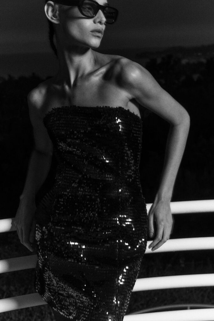 A fitted black strapless dress adorned with sequins in a pencil silhouette.