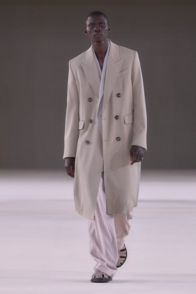A relaxed beige wool coat with a double-breasted design and long sleeves.