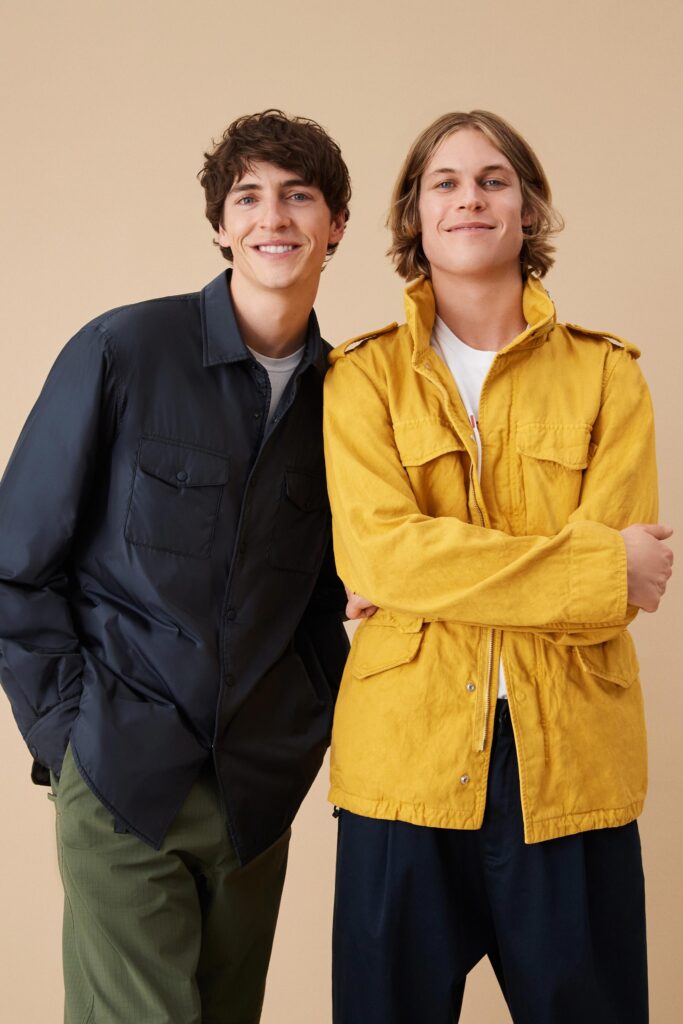 Two relaxed jackets in black and yellow with long sleeves and collared designs.