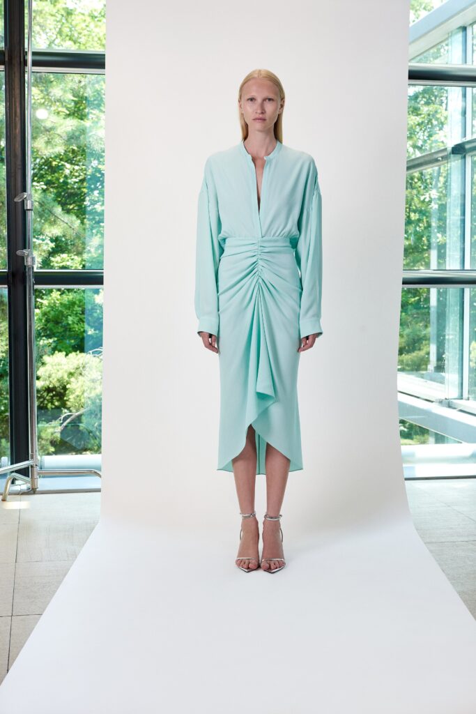 A fitted mint silk long-sleeve dress with a V-neckline and ruched asymmetric detail.