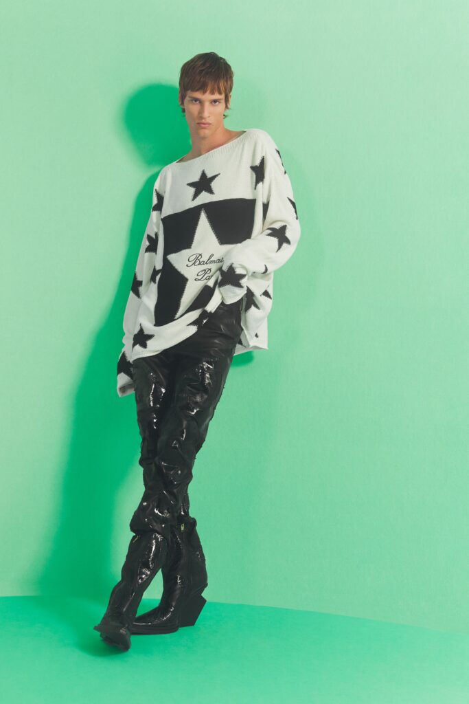 An oversized black and white sweater paired with high-waisted black leather pants.