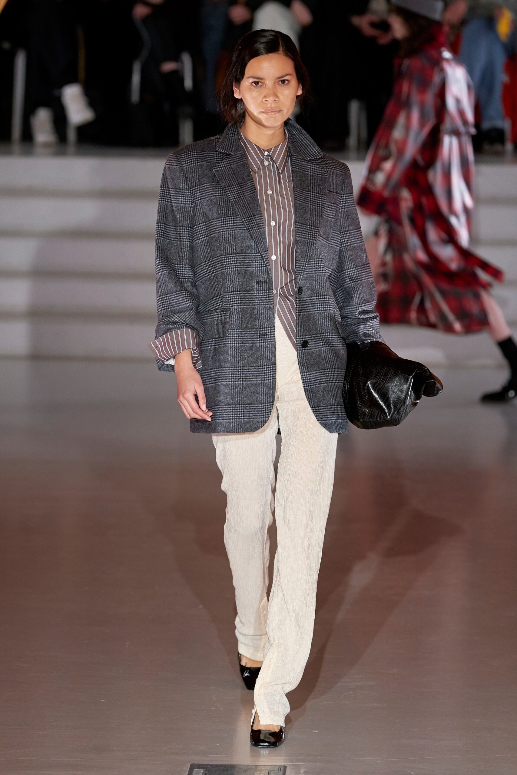 A tailored gray checked blazer paired with beige straight-leg pants and a collared shirt.