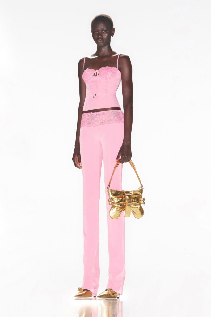 A fitted pink sleeveless top paired with matching fitted pants, showcasing a layered design.
