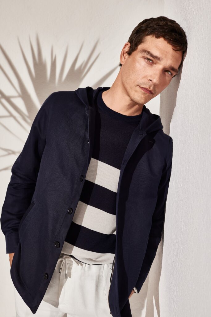 A relaxed navy jacket paired with a striped shirt, perfect for casual wear.