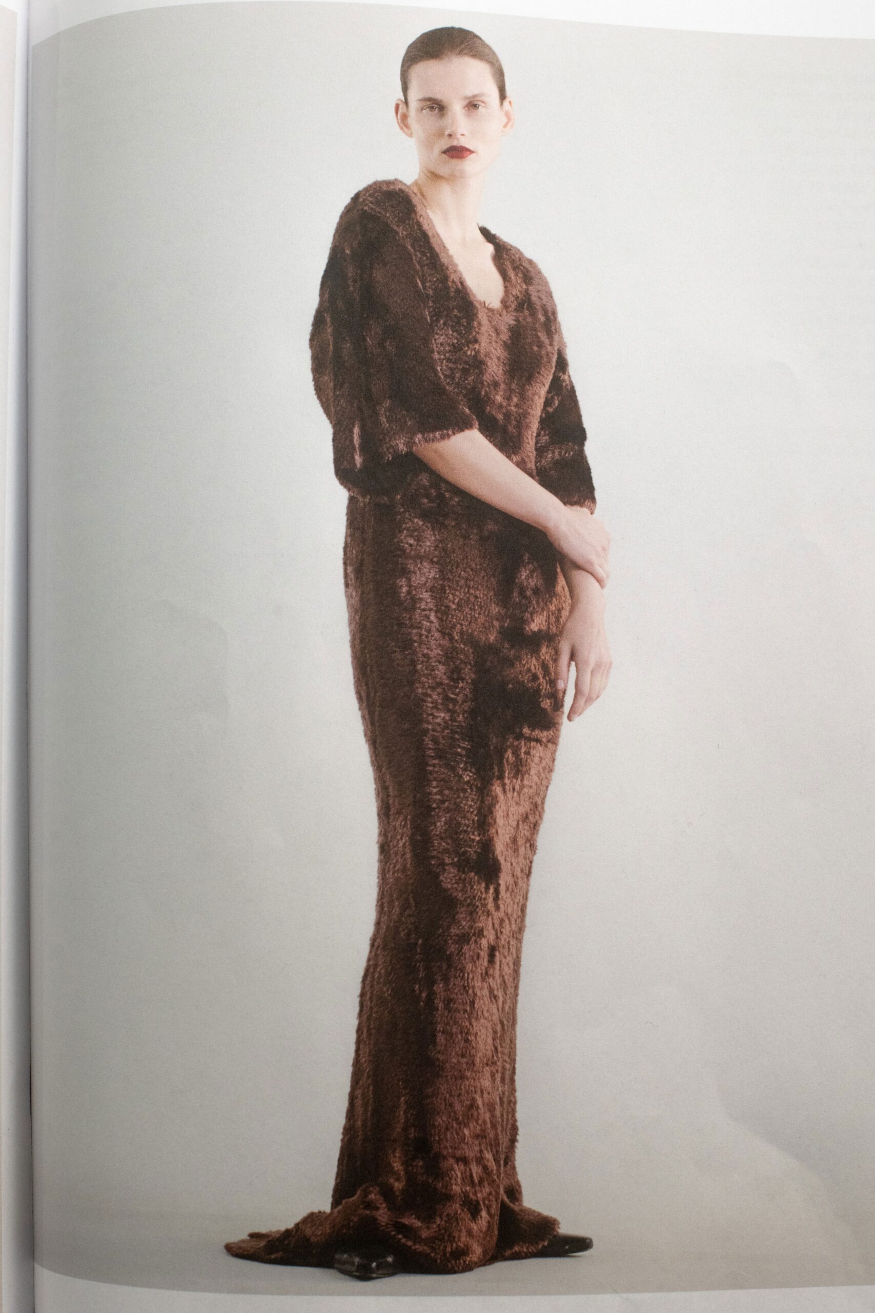 A fitted brown fur dress with a V-neckline and long sleeves, creating an elegant silhouette.