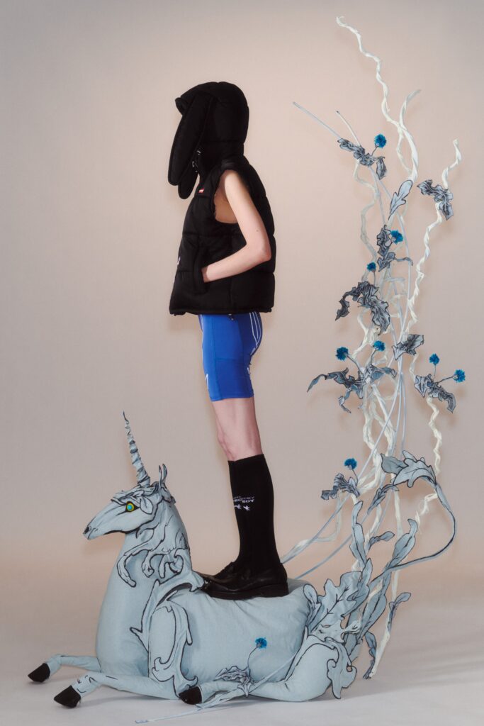 A relaxed black sleeveless vest paired with blue shorts featuring a zippered detail.