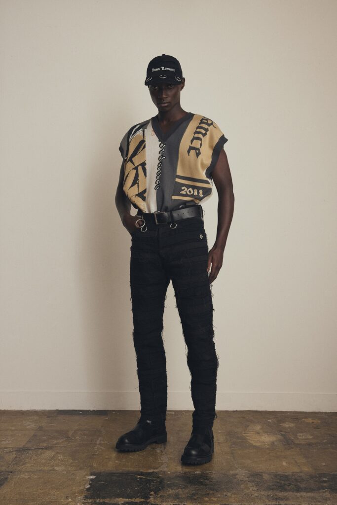 A relaxed beige printed top with a V-neck and short sleeves, paired with black denim pants.