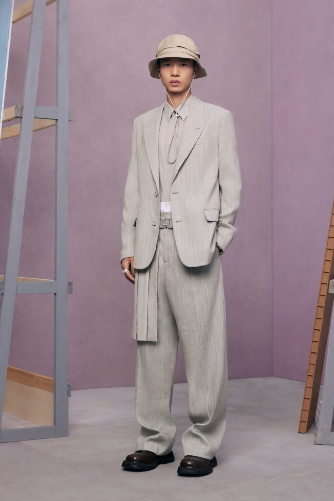 A tailored beige cotton suit featuring a long-sleeve shirt and wide-leg trousers.