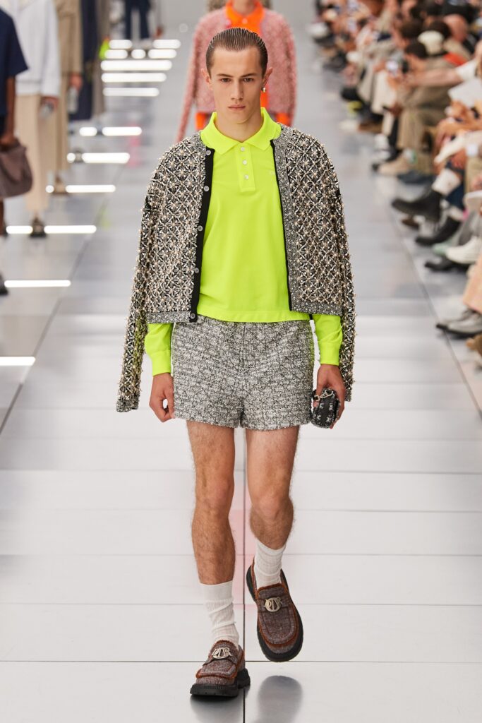 A relaxed-fit neon collared shirt paired with gray tweed shorts, featuring a layered look.