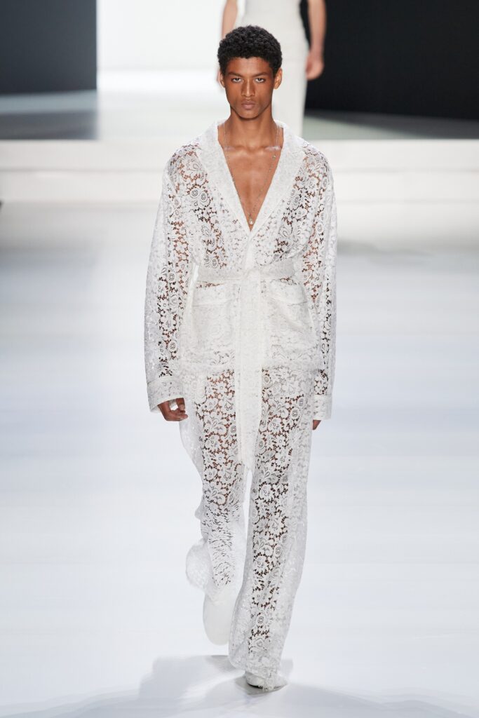 A relaxed white lace coat with a V-neckline and long sleeves, featuring a sheer design.