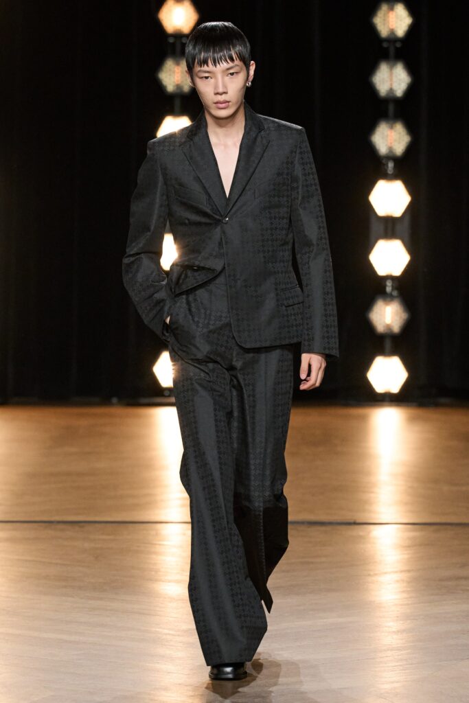 A tailored black suit with a V-neckline and straight-leg trousers, exuding sophistication.