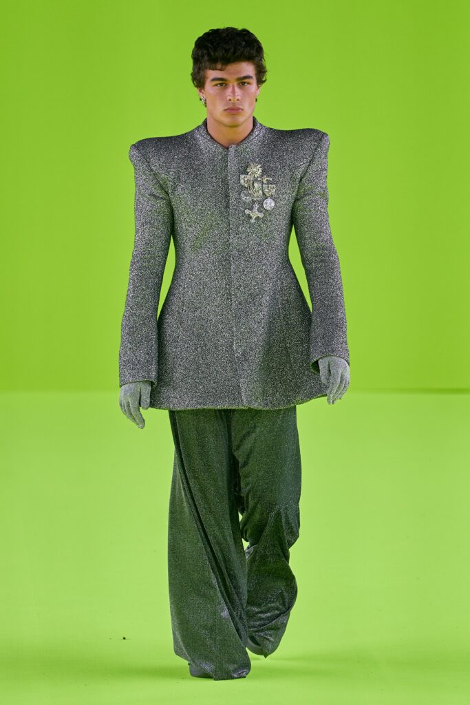 A tailored gray metallic suit with long sleeves and an asymmetric design detail.