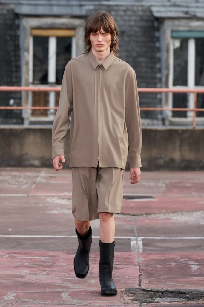 A relaxed beige shirt with a collared neckline paired with matching shorts.