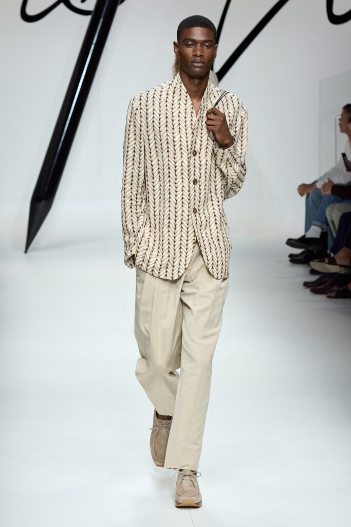 A relaxed-fit beige striped long-sleeve shirt paired with cream pants.