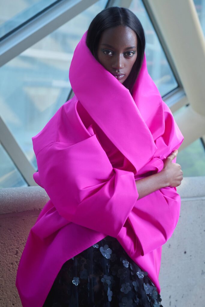 oversized pink coat with pleated black skirt