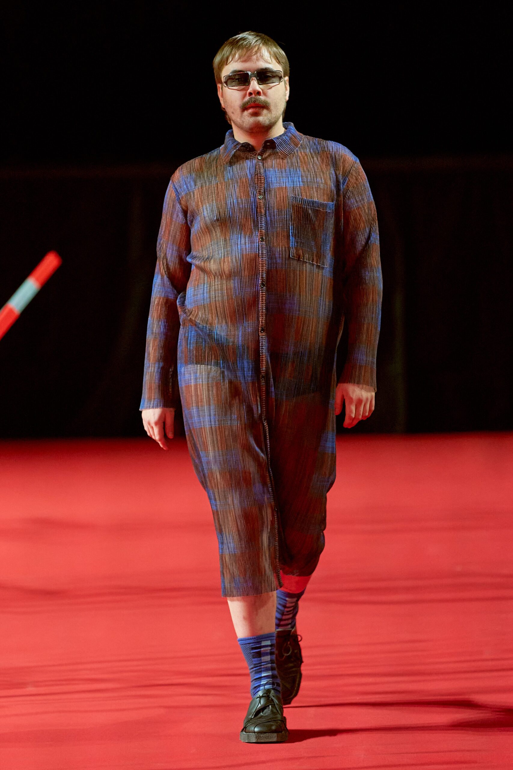 A relaxed blue and brown striped jumpsuit with long sleeves and a collared neckline.