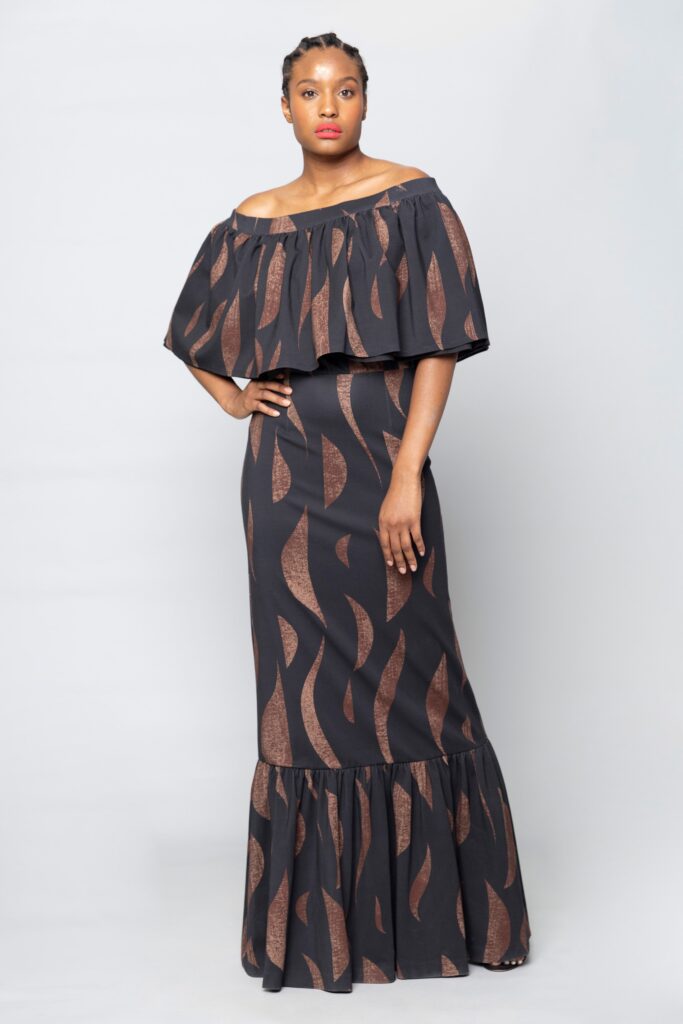 A fitted black and brown tiered dress with an off-shoulder design.