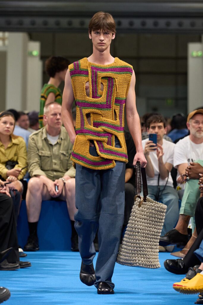 A relaxed sleeveless top featuring a layered design in yellow and purple, paired with blue pants.