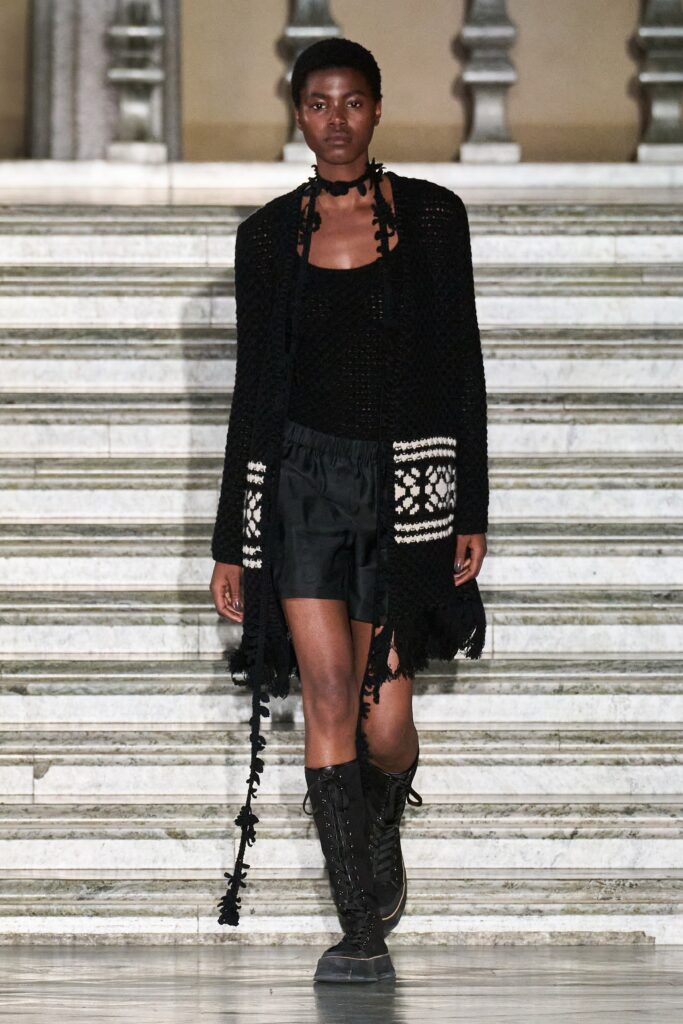 A relaxed black sleeveless top paired with black shorts, featuring a layered design.