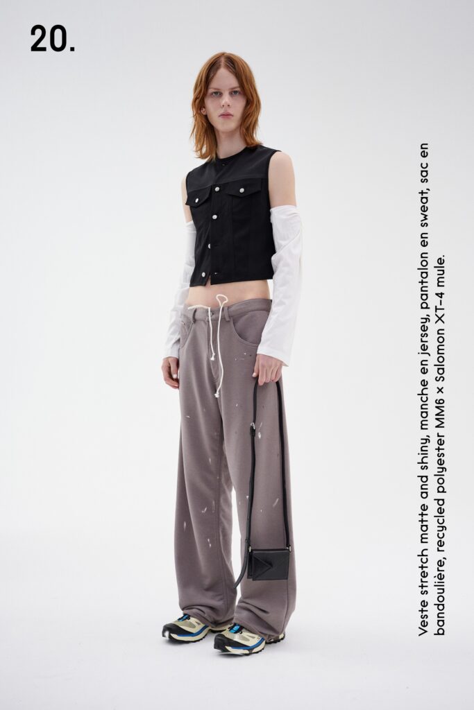 A relaxed black top with a collared long-sleeve design paired with gray pants.