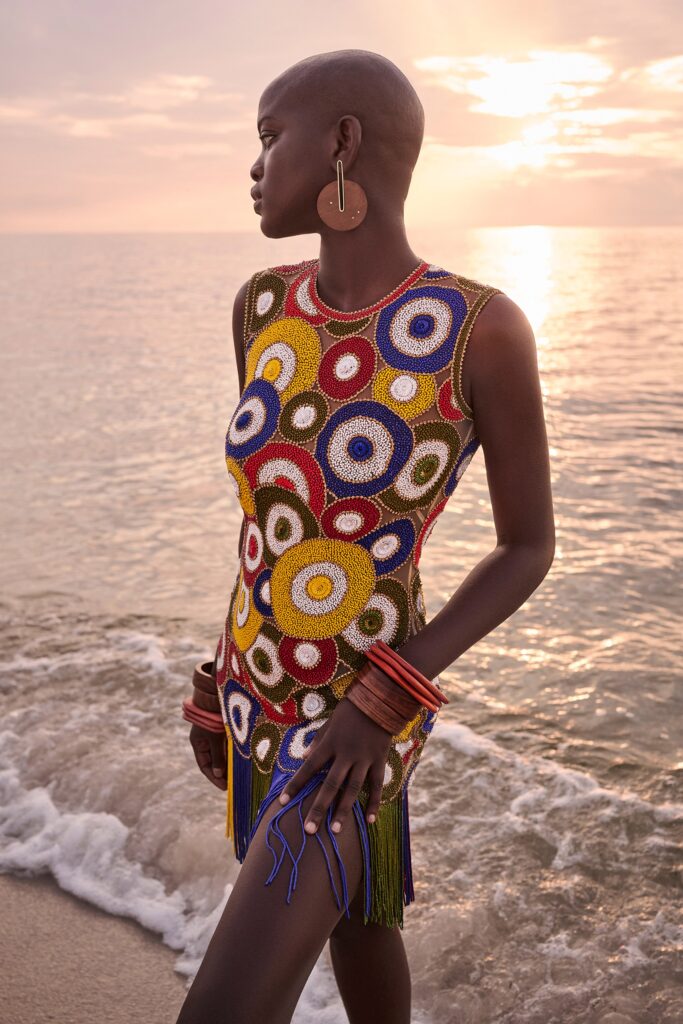A fitted multicolor sleeveless dress with a high neckline and fringed detailing.