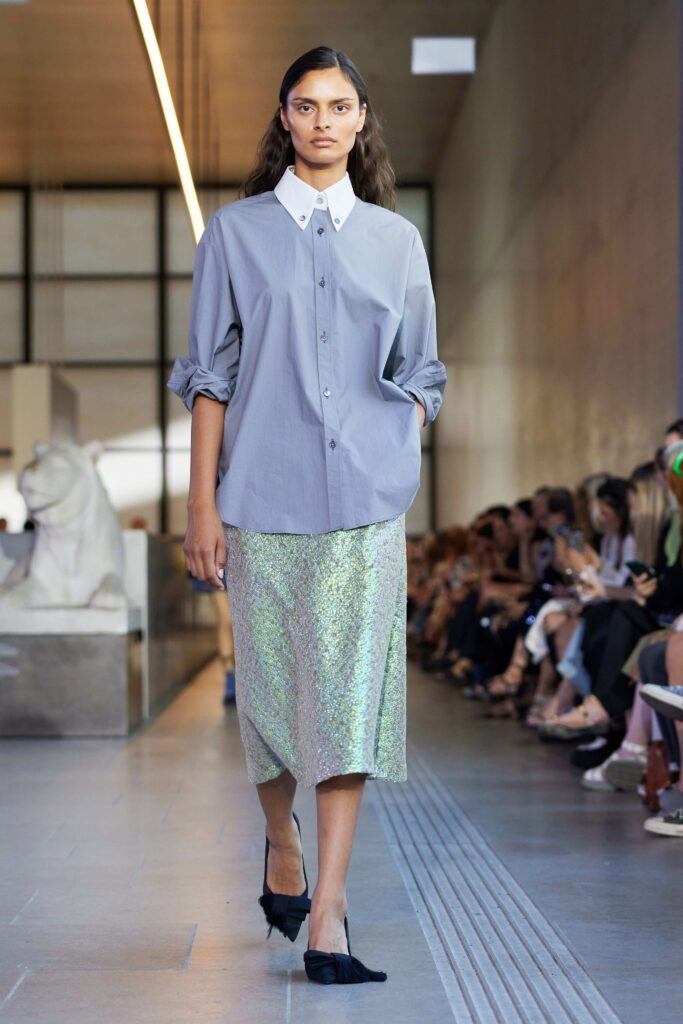 A fitted gray buttoned shirt paired with a multicolor asymmetric silk skirt, perfect for a chic look.