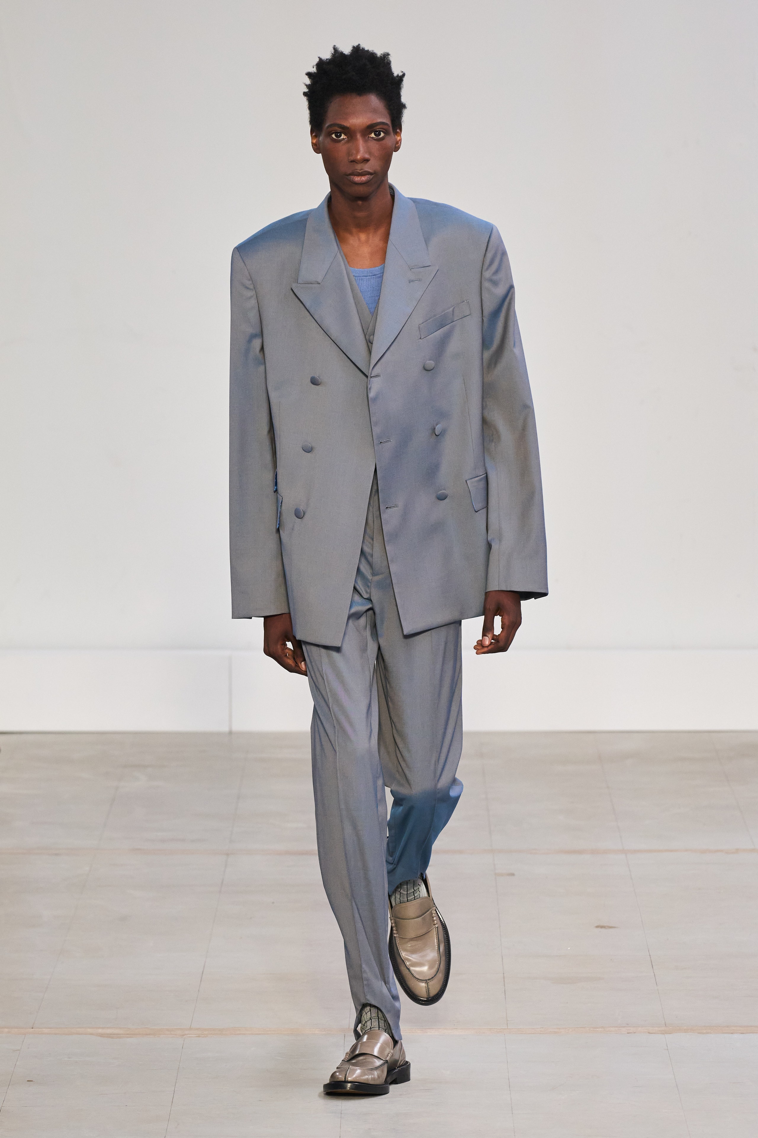 An oversized gray suit with long sleeves and a collared design, featuring buttoned details.