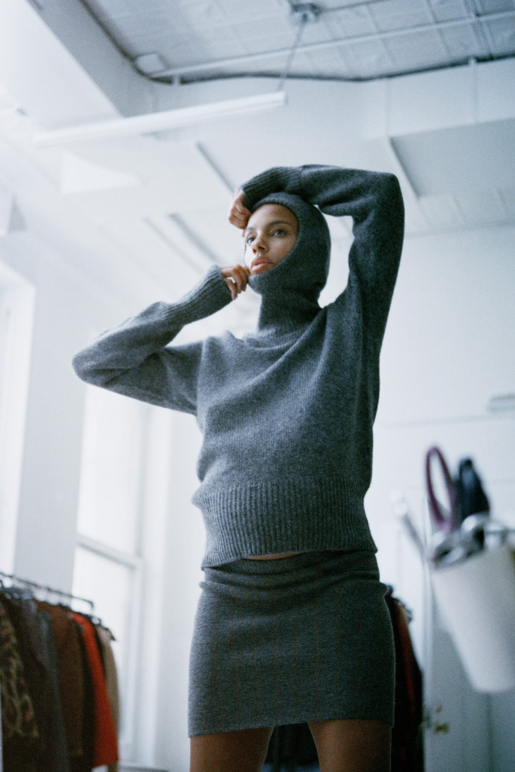 A fitted gray wool sweater with a turtleneck and a mini skirt, creating a chic look.