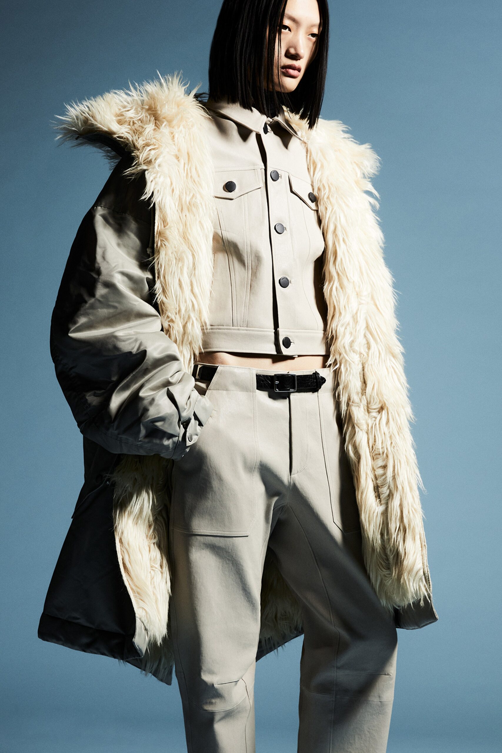 A relaxed beige faux-fur coat paired with cotton pants featuring a collared design.