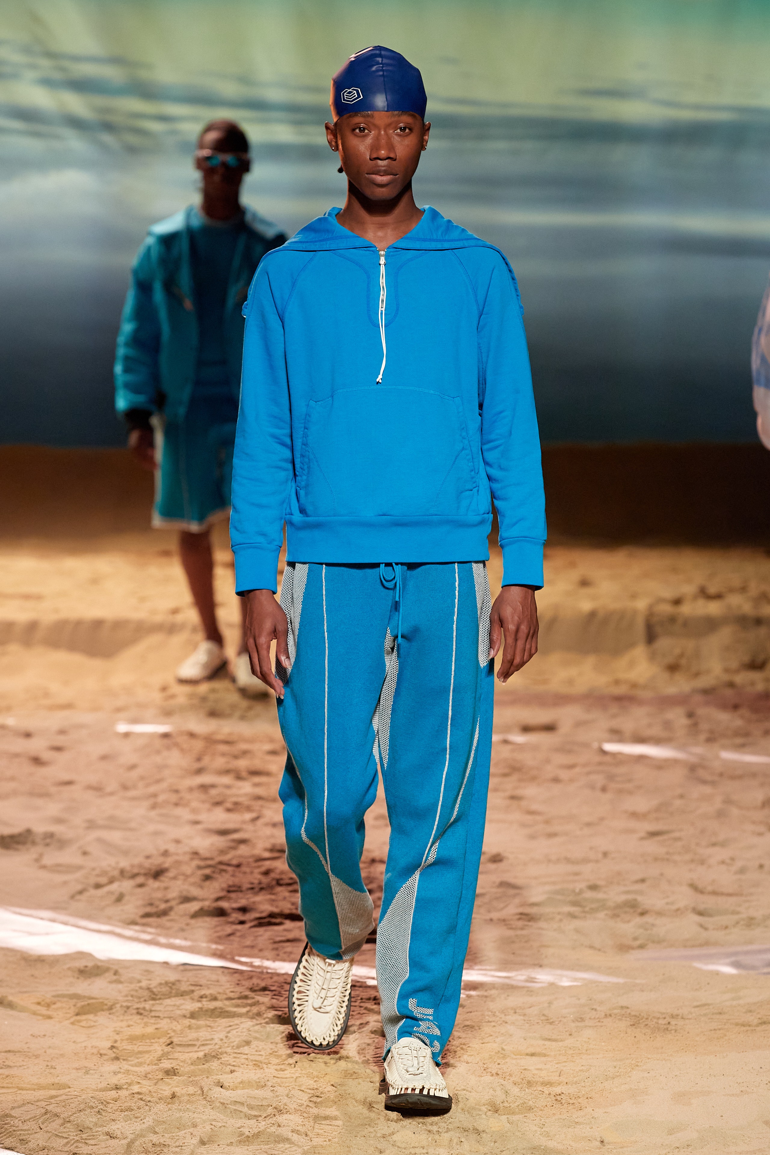 A relaxed blue hoodie with long sleeves and matching pants featuring striped details.