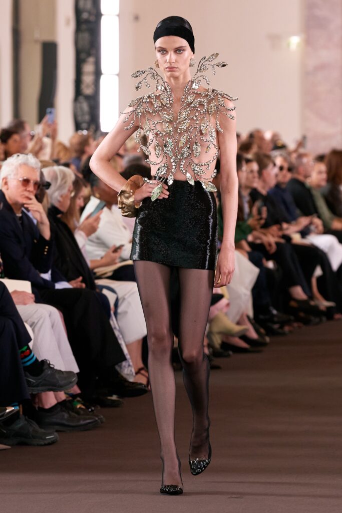 A fitted black silk sleeveless dress with a V-neckline and mini silhouette.