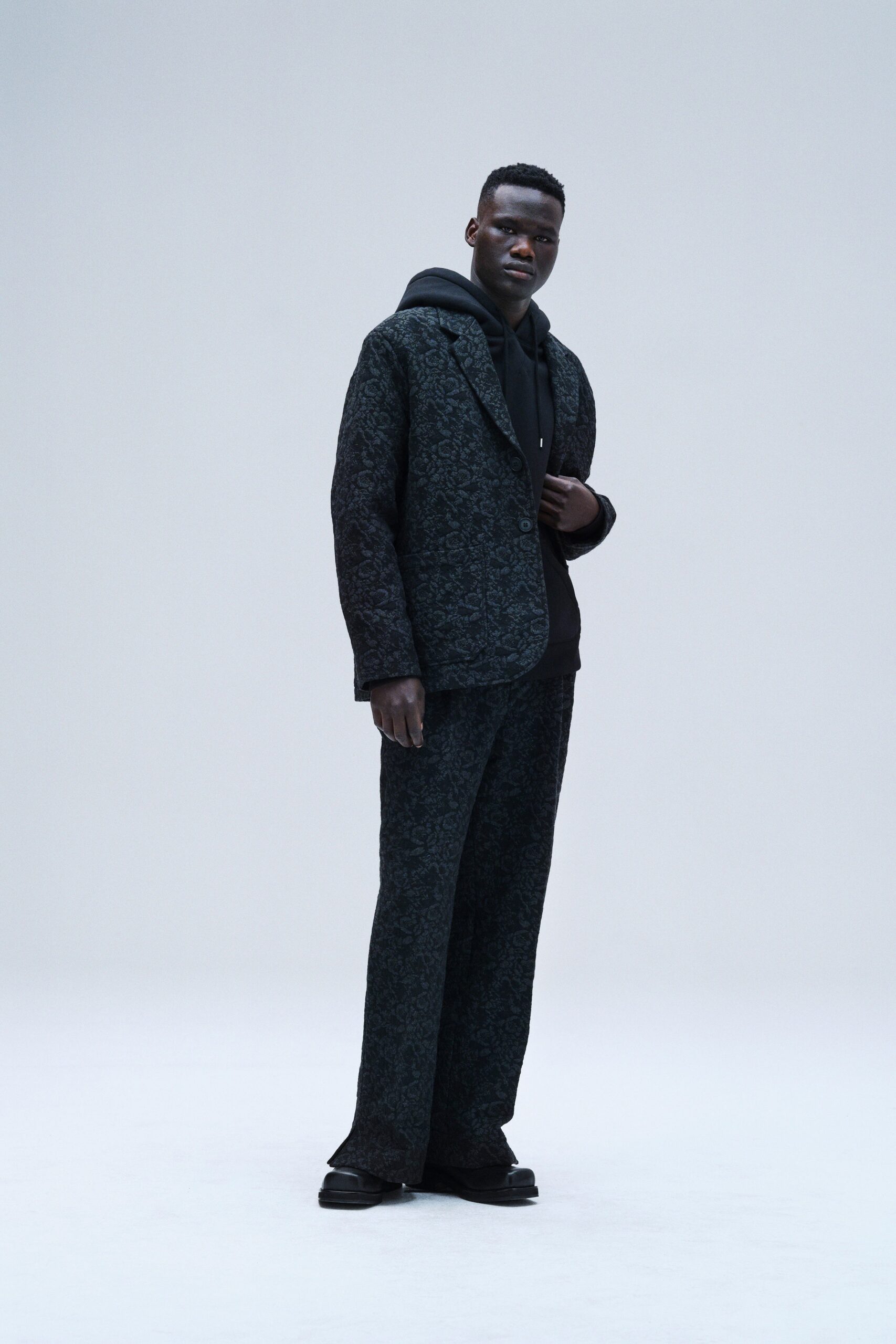A relaxed black printed jacket with a hood paired with matching pants.