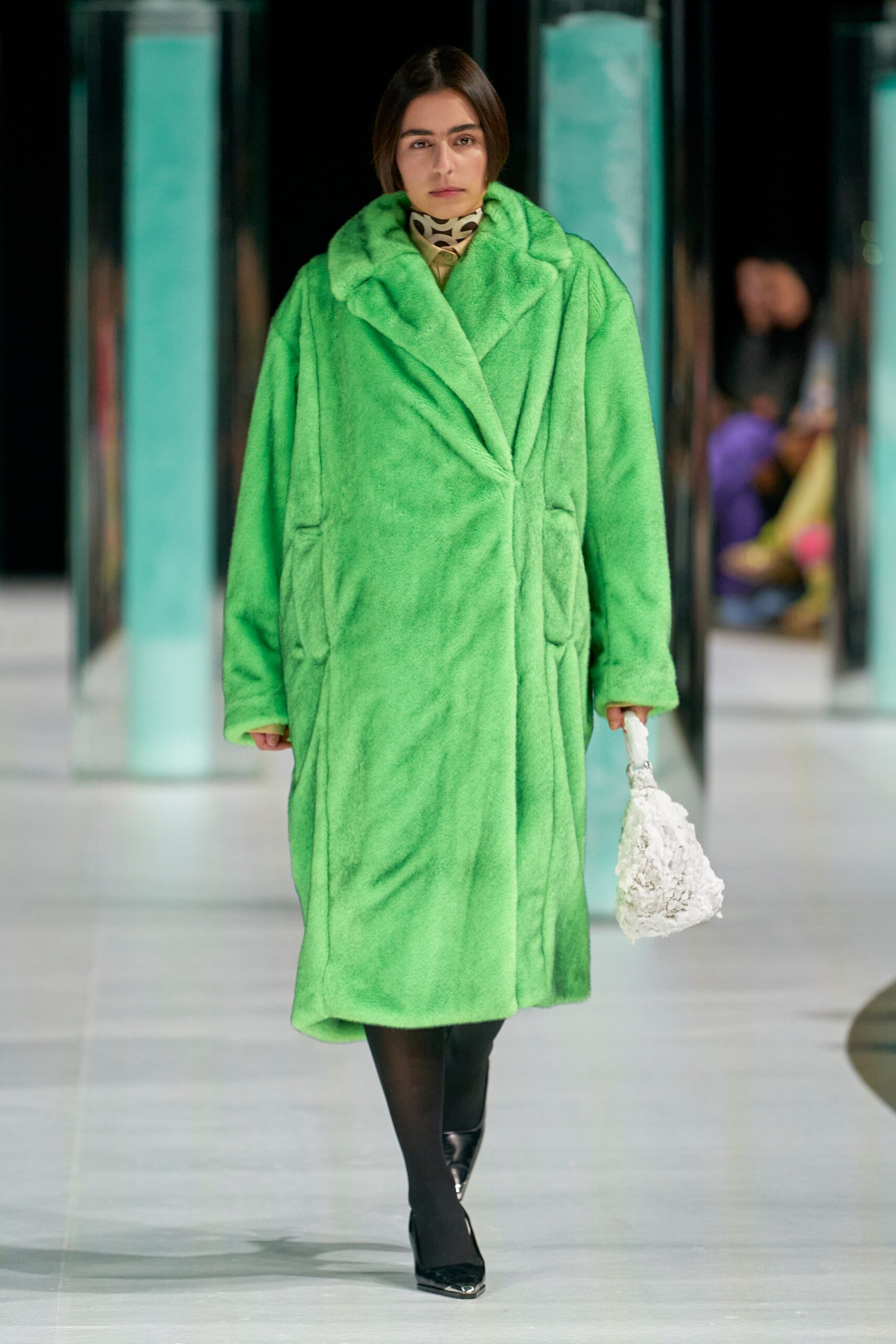 An oversized green faux-fur coat with long sleeves and a collared design.