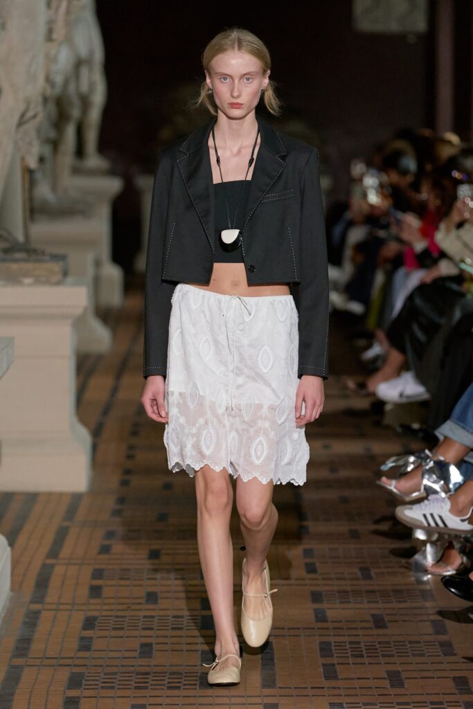 A fitted black jacket paired with a layered white skirt featuring an asymmetric design.