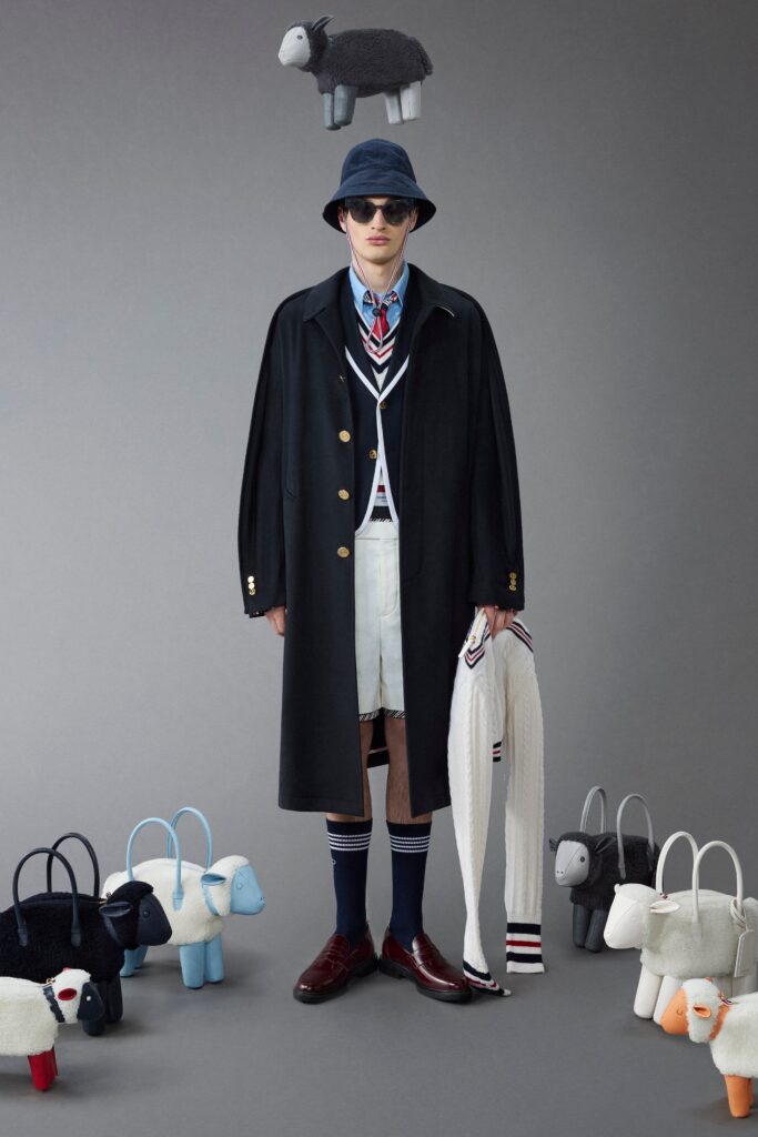 A relaxed black coat layered over a collared shirt and high-waisted white shorts.