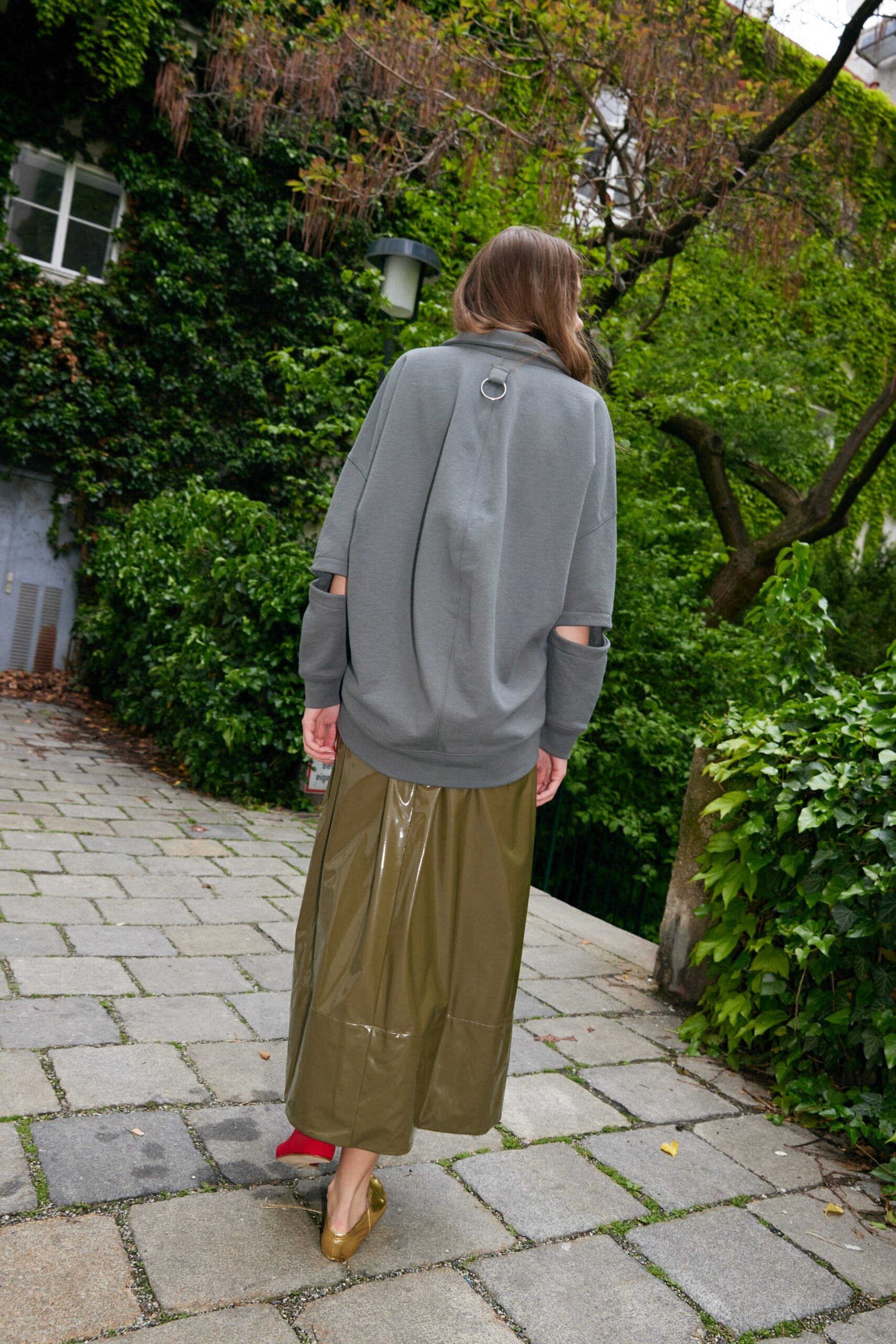 gray oversized top with green vinyl skirt