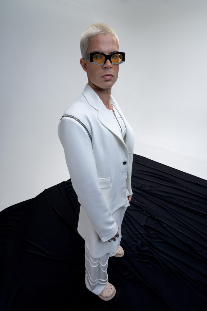 A tailored white suit with long sleeves and a collared design, featuring button details.