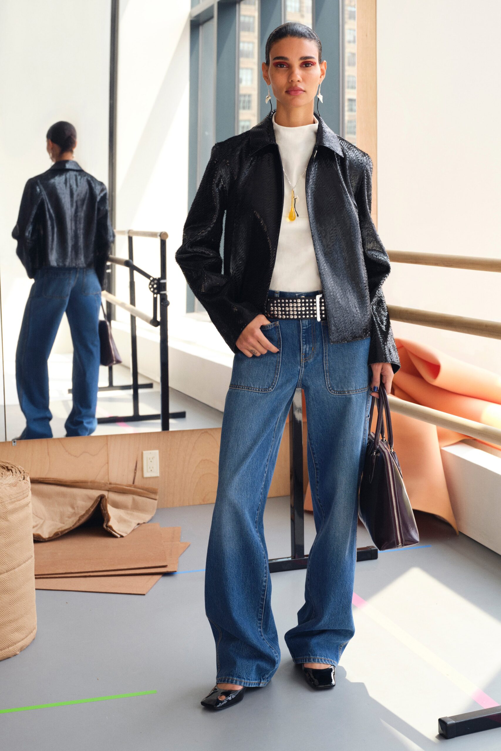 A relaxed black jacket paired with wide-leg blue denim pants, featuring a collared design.