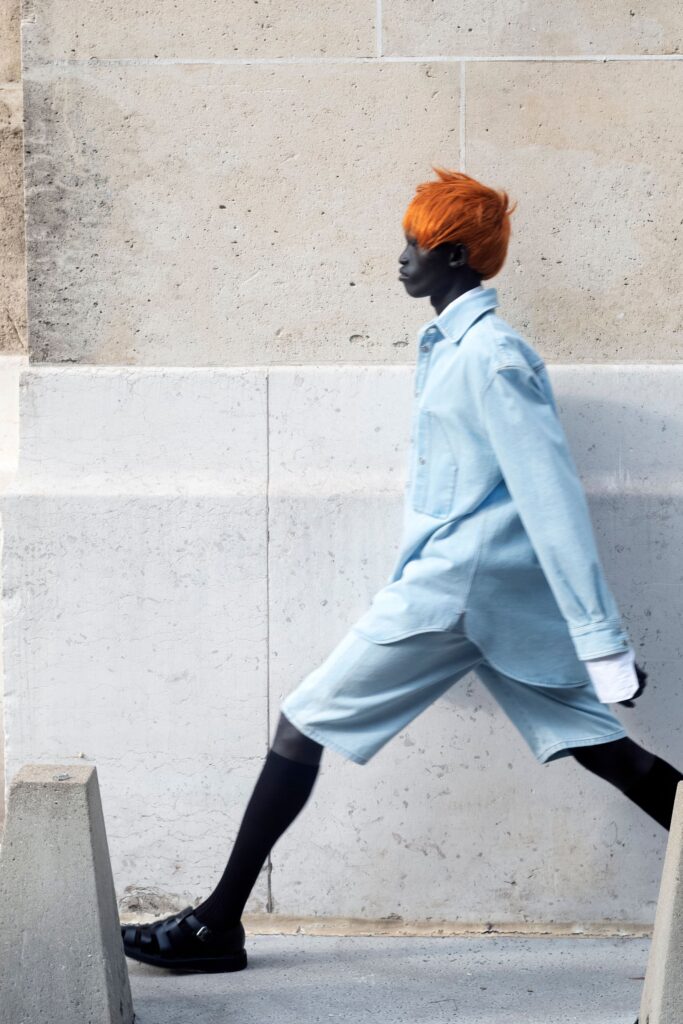 A relaxed blue denim shirt paired with matching shorts, featuring a collared design and buttoned detail.